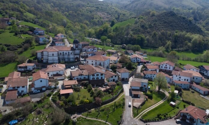 A picturesque village nestles amongst green hills