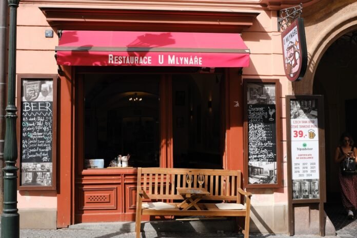 image_1788451236988 Restaurant entrance with red awning and wooden bench