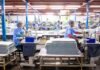 El Mercado Laboral de Estados Unidos Sorprende con 162.000 Nuevos Empleos en Agosto: Señales de una Economía Resiliente Workers sew textiles in a large factory setting
