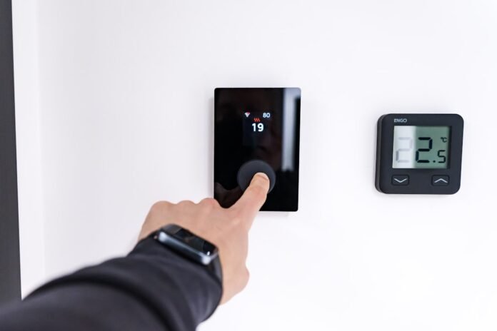 image_1788634833933 Finger adjusting a modern digital thermostat on wall