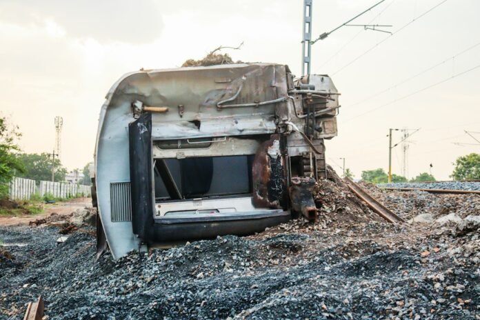 A train car lies overturned next to tracks