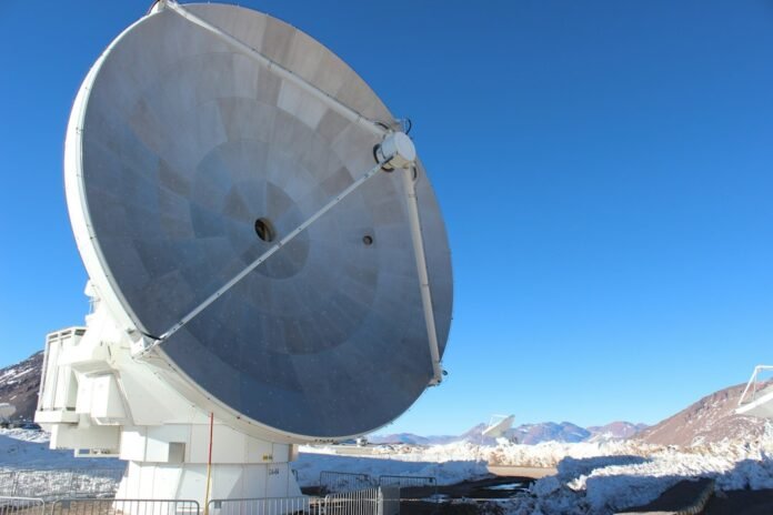 a large satellite dish sitting on top of a snow covered ground