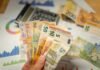 Financiación de 280 millones para pymes españolas: el acuerdo BEI-Banca March que impulsa la economía productiva A person holding a bunch of money in front of a calculator