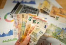 Financiación de 280 millones para pymes españolas: el acuerdo BEI-Banca March que impulsa la economía productiva A person holding a bunch of money in front of a calculator