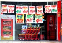 El precio oculto del pollo barato: trabajadores y granjeros pagan la factura que no aparece en el supermercado A grocery store window displaying price tags