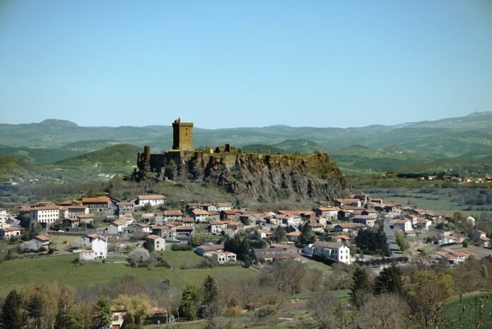 a village on a hill with a castle in the background