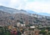 Pantallas que atrapan: cómo las ciudades están combatiendo la adicción tecnológica con arte y conciencia social a city with mountains in the background