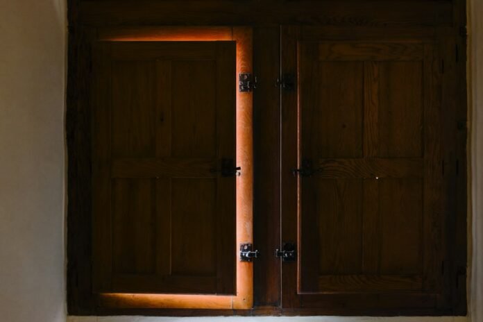 a pair of wooden doors are open in a room