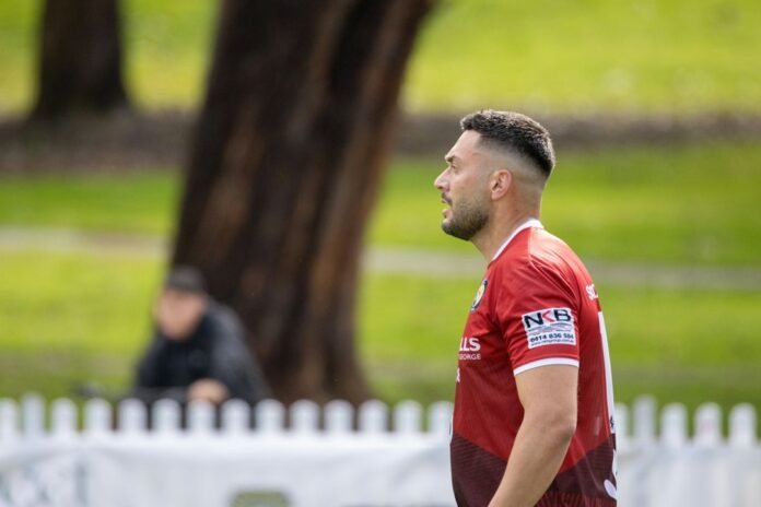 Man in red jersey looking away on a field