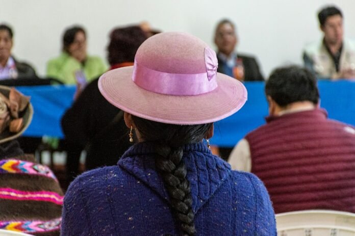 a woman wearing a pink hat in front of a group of people