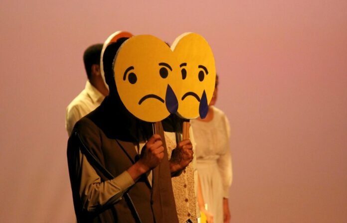 image_1791637236093 a woman holding a cardboard heart with a sad face on it