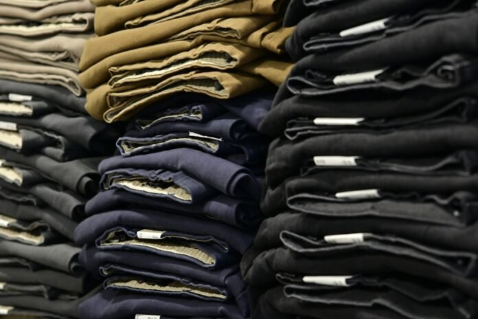 Piles of folded pants neatly stacked on shelves