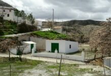 Pisos turísticos y vivienda: el problema que nadie quiso ver durante una década White buildings with green doors in a rural landscape under a cloudy sky