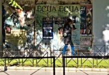 La deuda pública española: una bomba de relojería que amenaza la estabilidad económica futura Woman walks past a wall of torn posters
