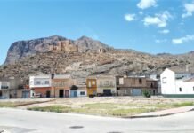 El Defensor del Pueblo: Función, Elección y Retribución del Garante Constitucional de los Ciudadanos Españoles Small town nestled at the base of a large mountain