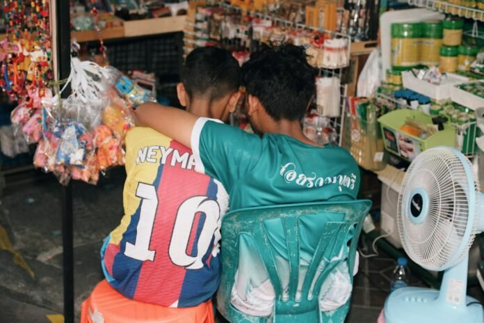 Two boys sitting together with arms around each other
